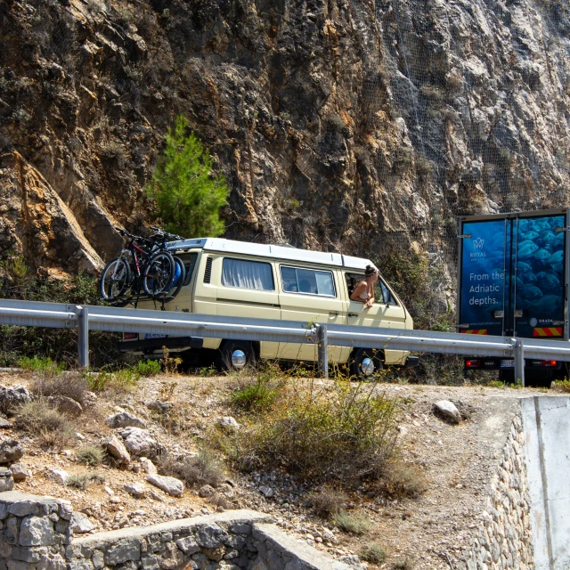 a van with a trailer attached to it in front of a mountain