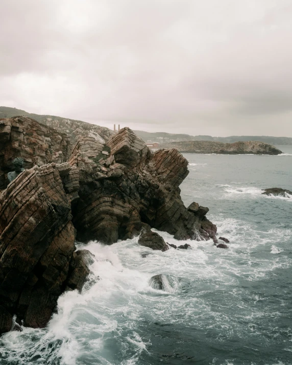 waves crashing into a rocky shore and rock formation