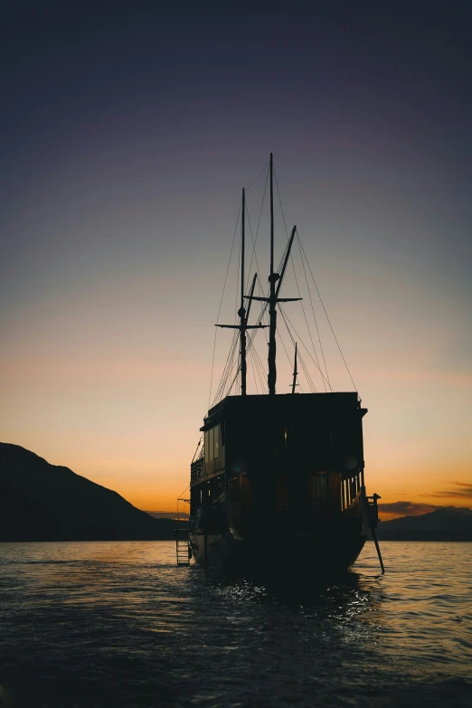 an old, wooden boat on the water at sunset