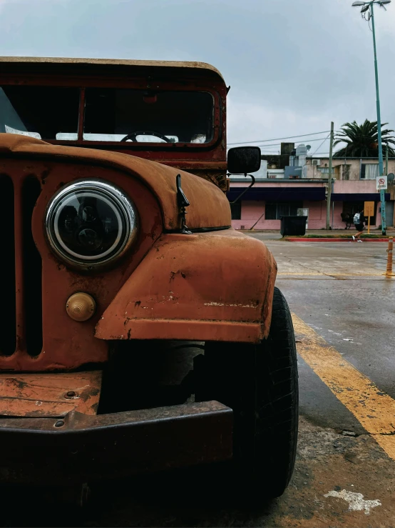 an old red truck parked on the side of a road