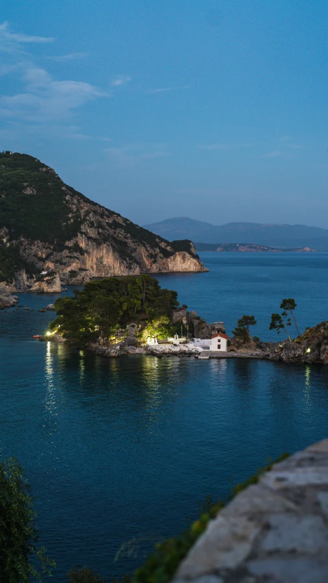 the lights are on a small island on a blue body of water