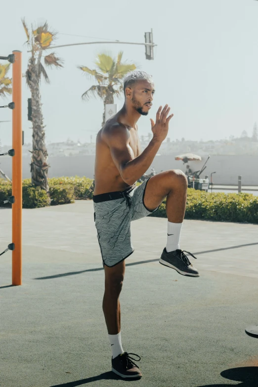 a shirtless man doing a trick on a basketball court