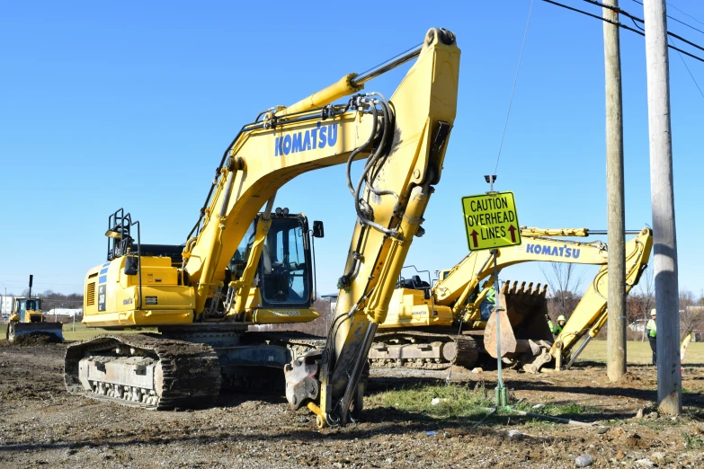 a yellow tractor is parked on a dirt field