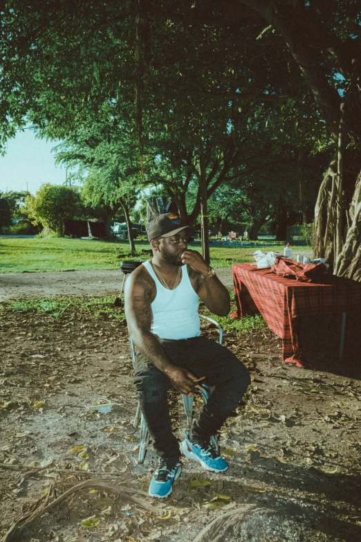 a man in a white tank top sits on a bench