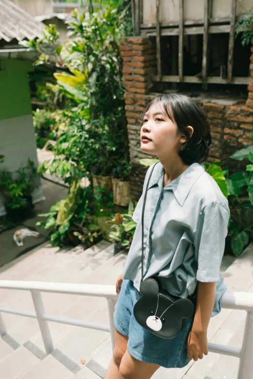 a girl in a blue dress holding a black purse