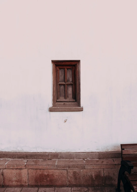 a bench is standing beside a building with a window