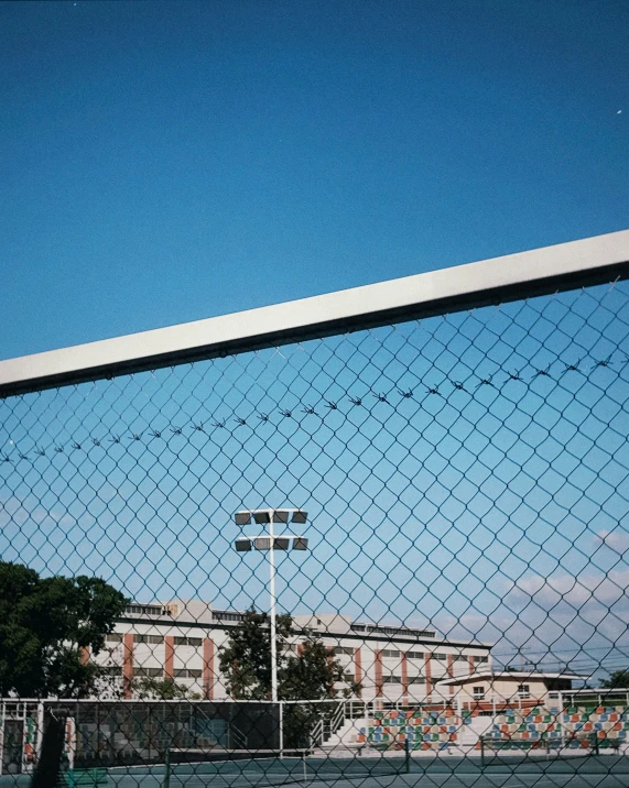 a tennis court is seen through a mesh net