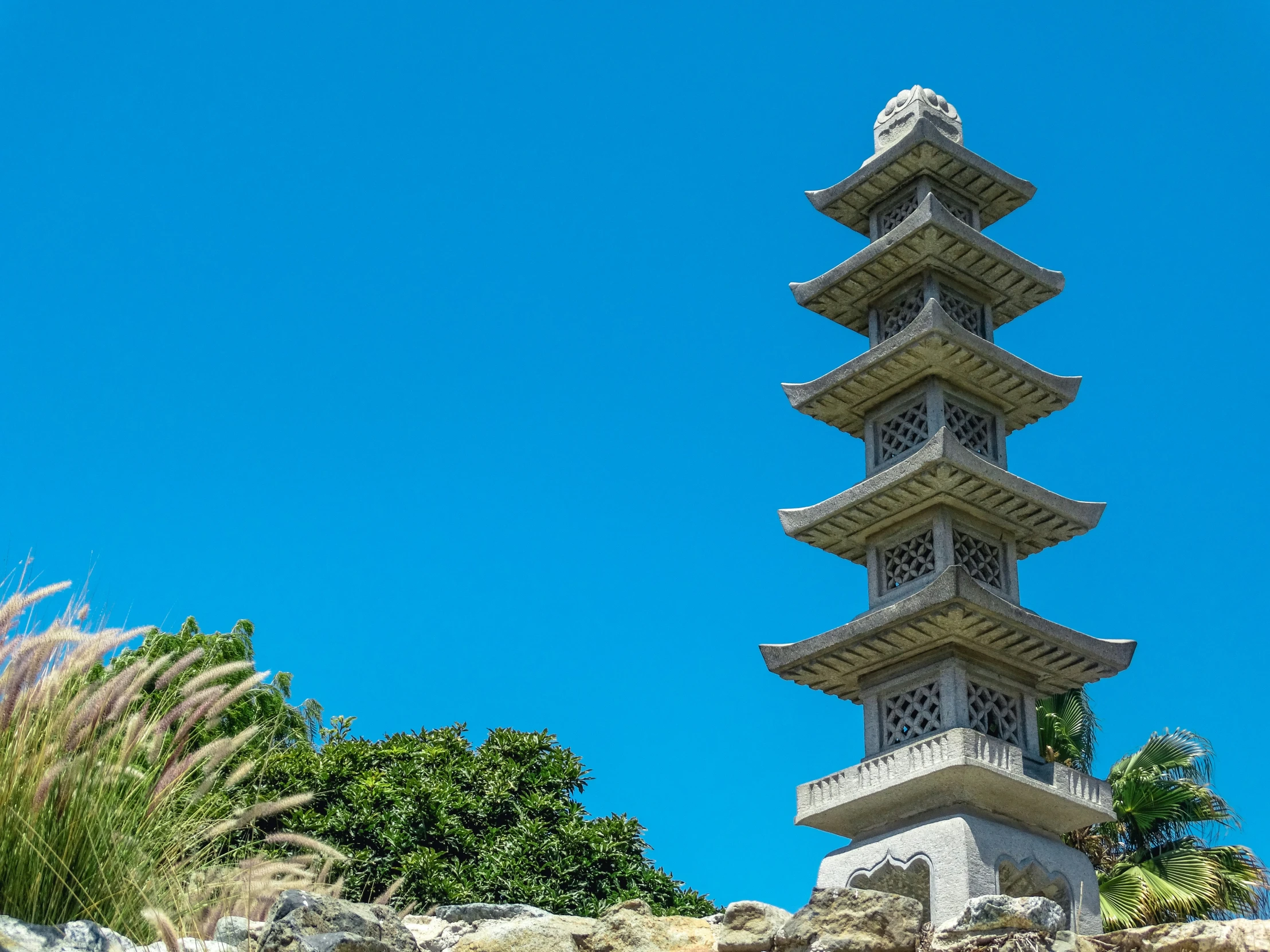 an asian pagoda with plants surrounding it