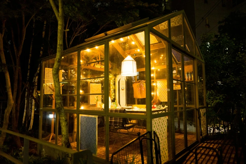 small wooden structure with lights in it by trees