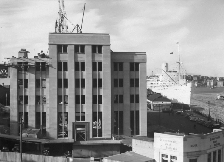 a black and white image of a building near the water