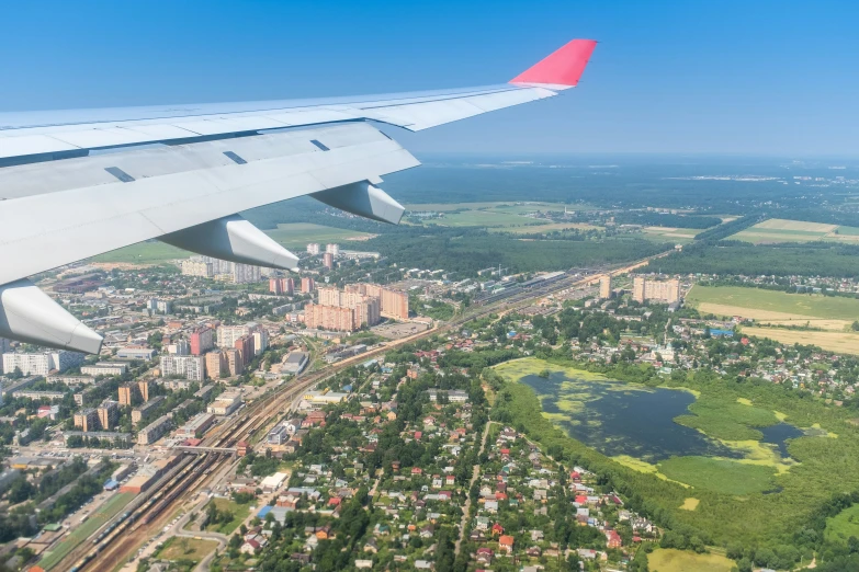 an airplane wing flying above a city below it