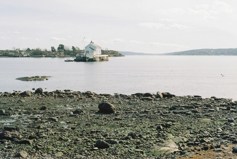 a small white building sitting on top of a body of water