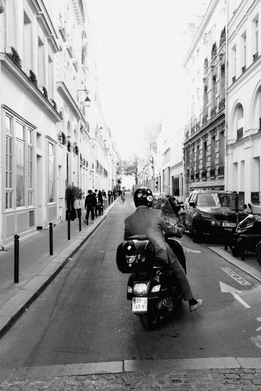 a motorcyclist rides through an alley in paris