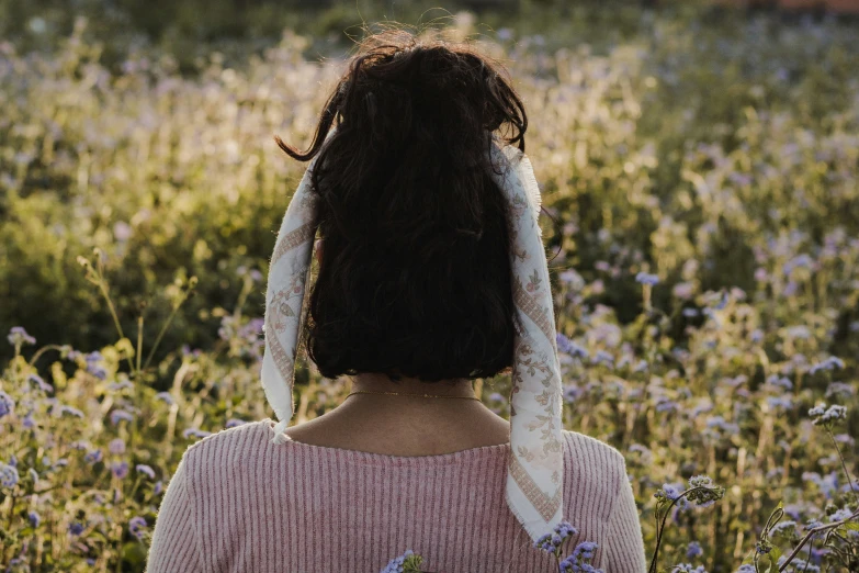 the back of a woman's head with flowers behind her