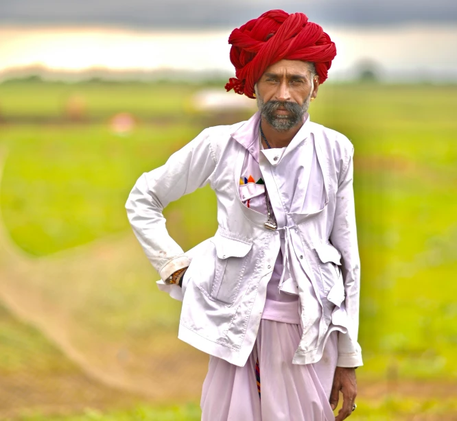 a man in a white jacket standing in the grass