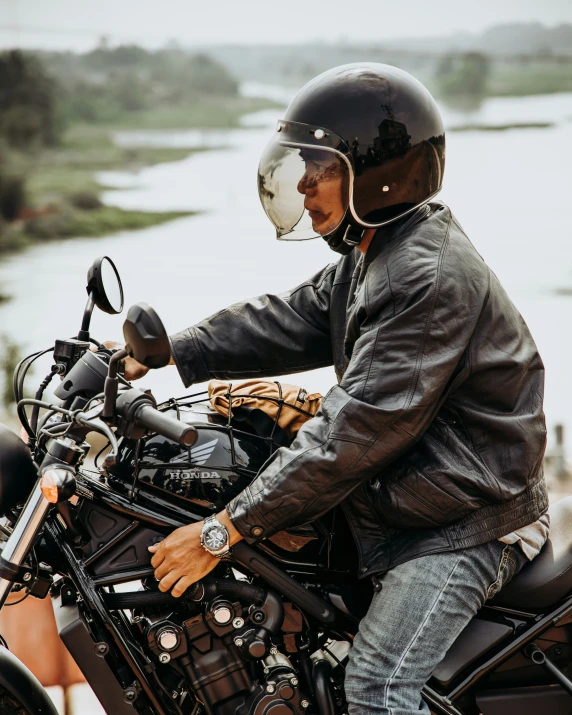 a man riding on the back of a black motorcycle