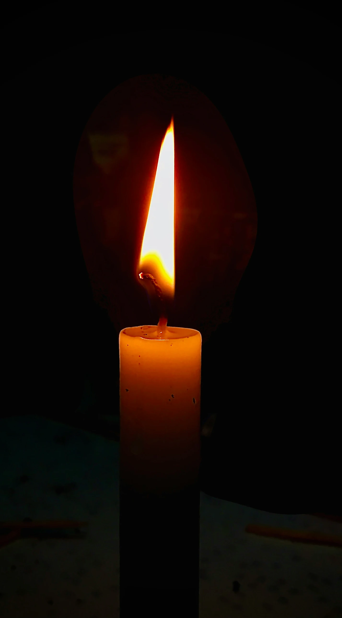 a lit candle is shown in a dark room
