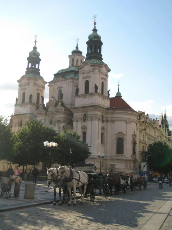 several horses and buggies are in front of the church