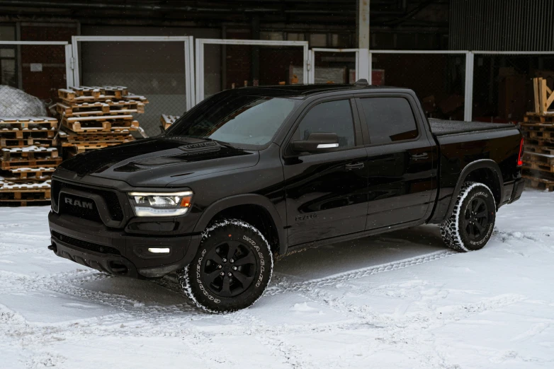 black truck sitting in the snow on a snowy day