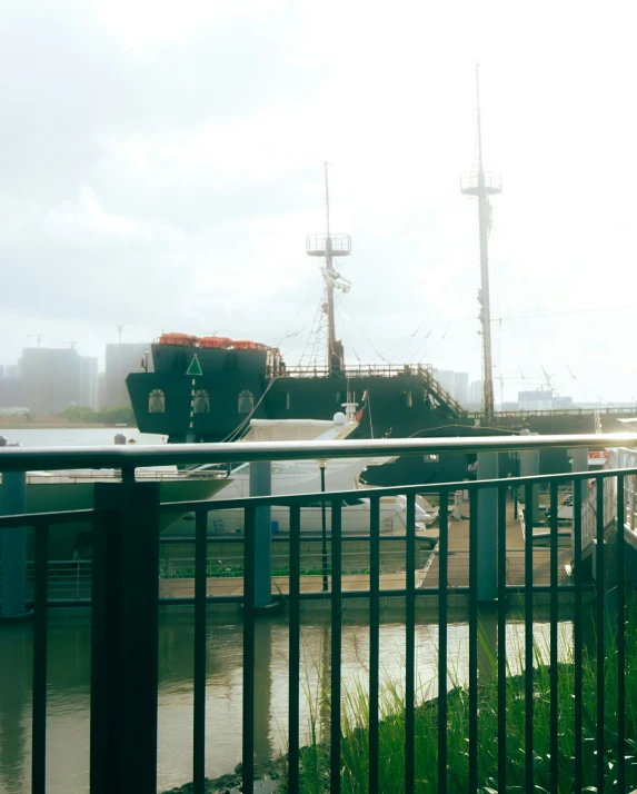 a boat on a body of water by a metal fence