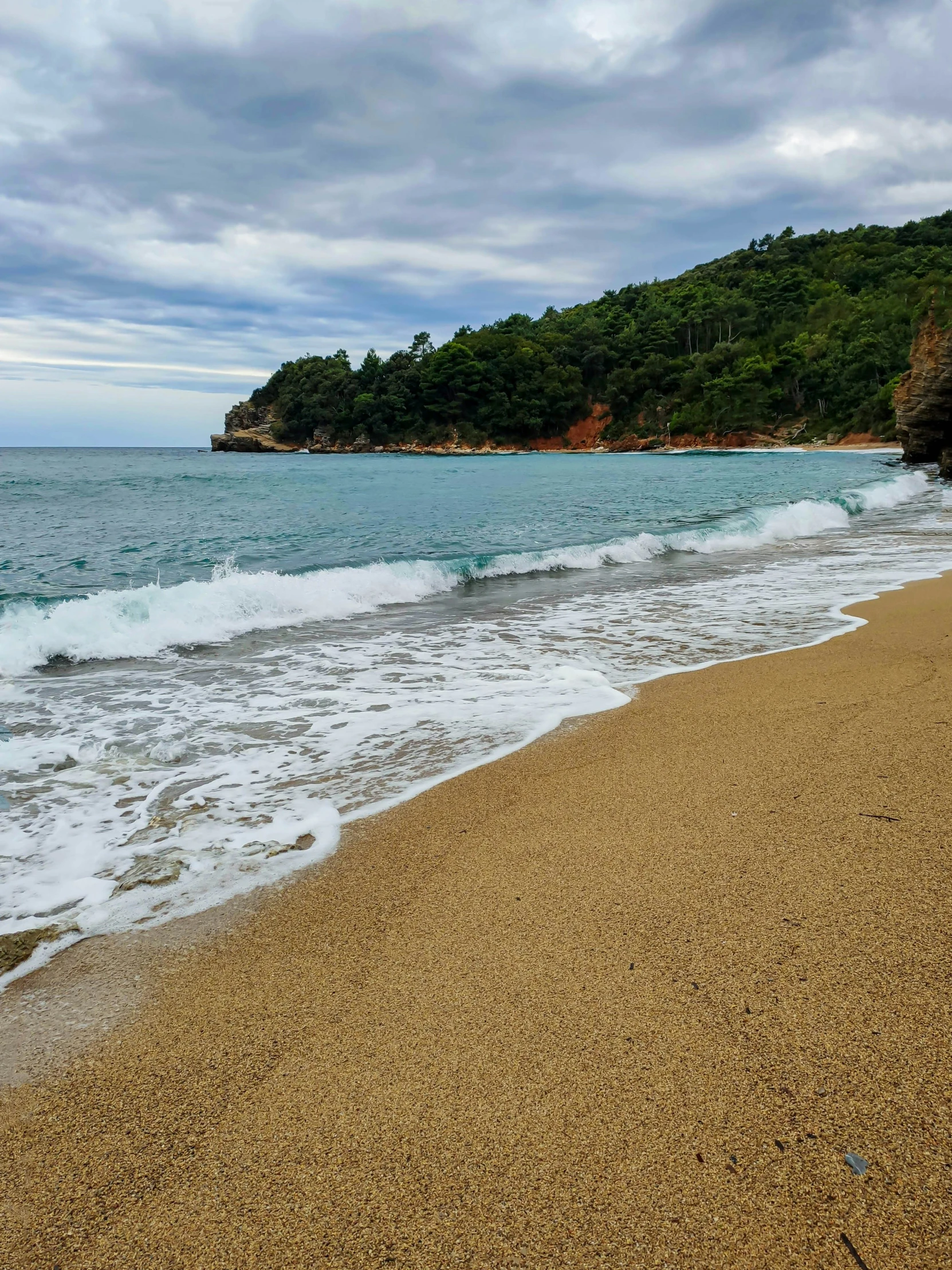 the shore is empty as waves lap up against a sandy beach