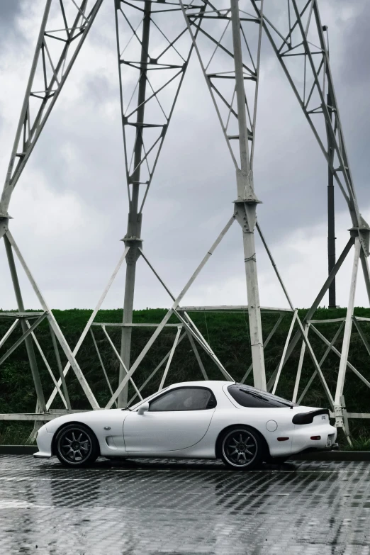 a white car is parked near a tall tower