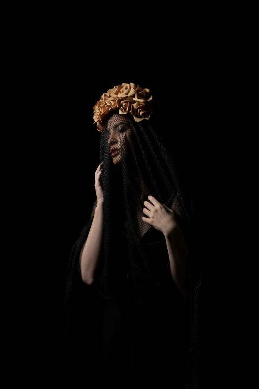 a woman wearing a black veil, veiled face and gold curly hair