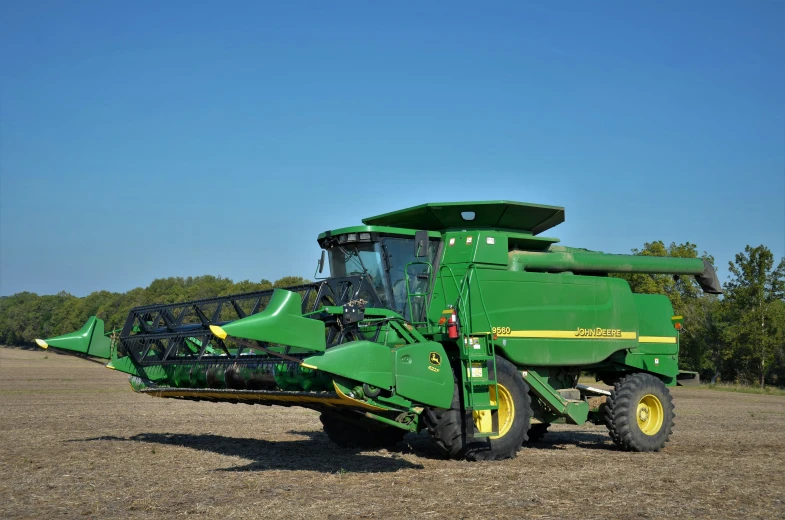 a green farming vehicle parked on a dirt field