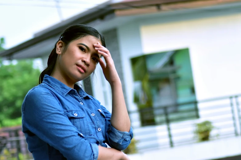 an indian woman with long hair holding her hand on her head