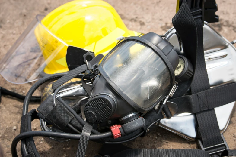 a helmet on a bag sitting beside two work helmets