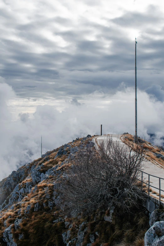 a small hill with some water and clouds