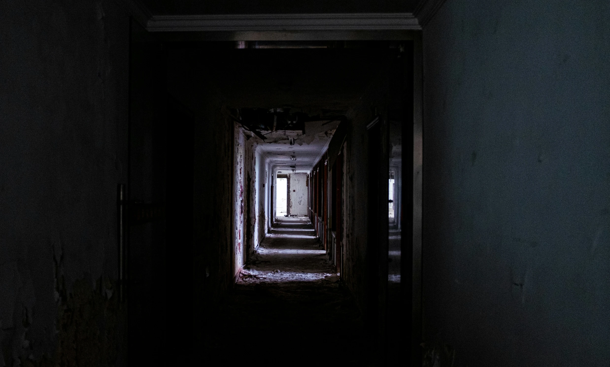 a dimly lit dark hallway with lights on