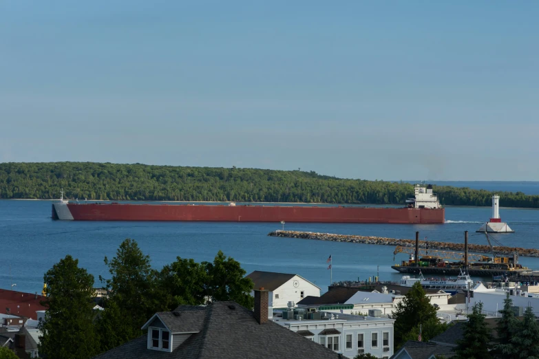 a cargo ship sailing across a river next to a town