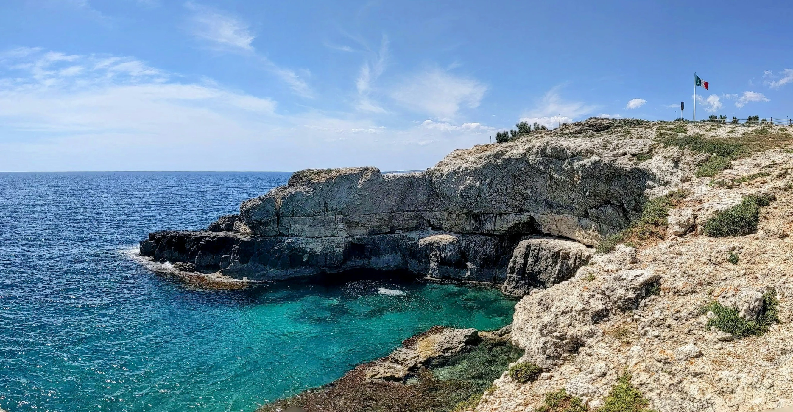 a man stands on top of a cliff above the ocean