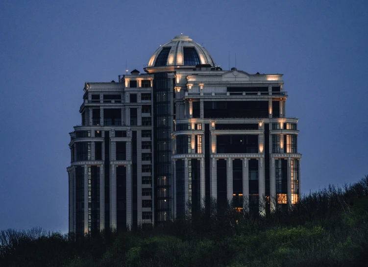 a tall building that has lights on and a sky background