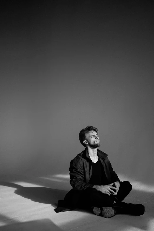 a man sitting on the floor in black and white