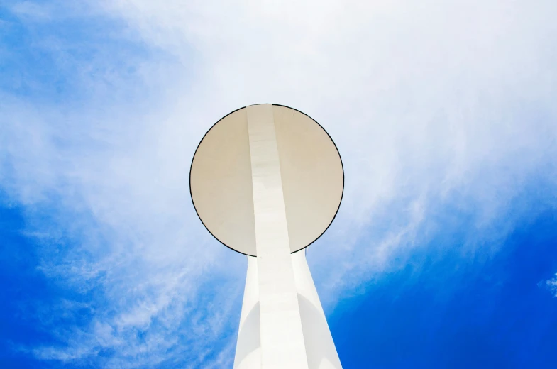 the sky is partly cloudy near a radio tower