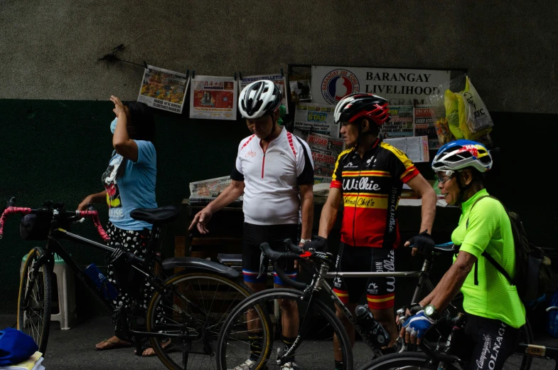 men are standing next to their bicycles talking