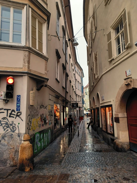 people walking on a street surrounded by brick buildings