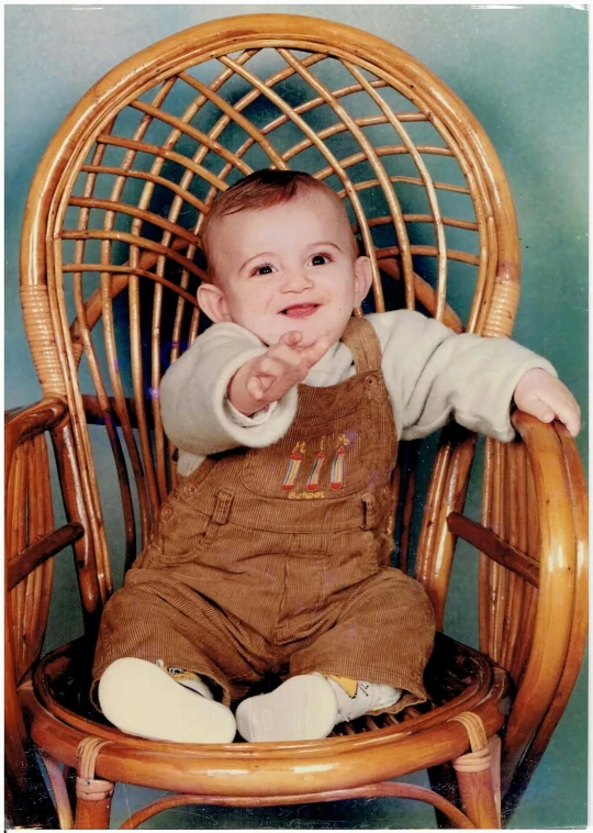 a small child is posing for a picture on a chair