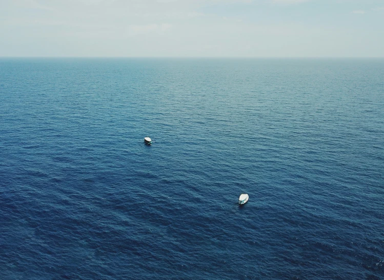 two boats that are sitting in the ocean