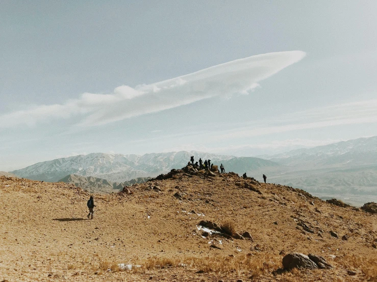 a group of people standing on a dirt hill