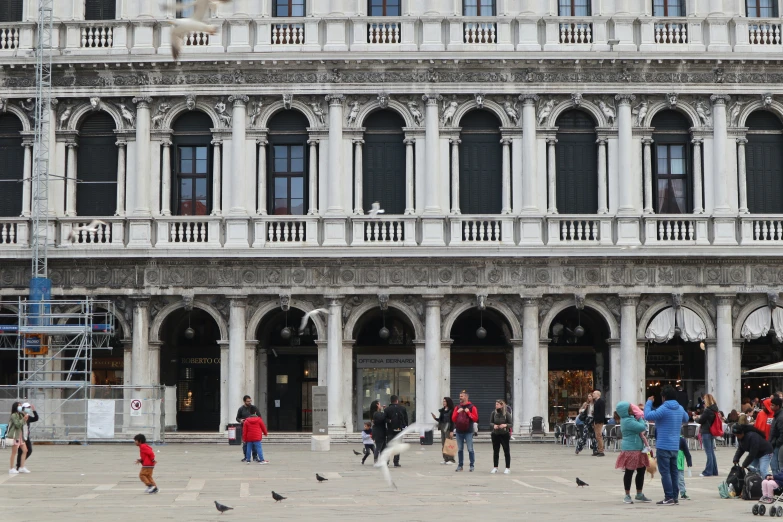 a large group of people standing around an old building