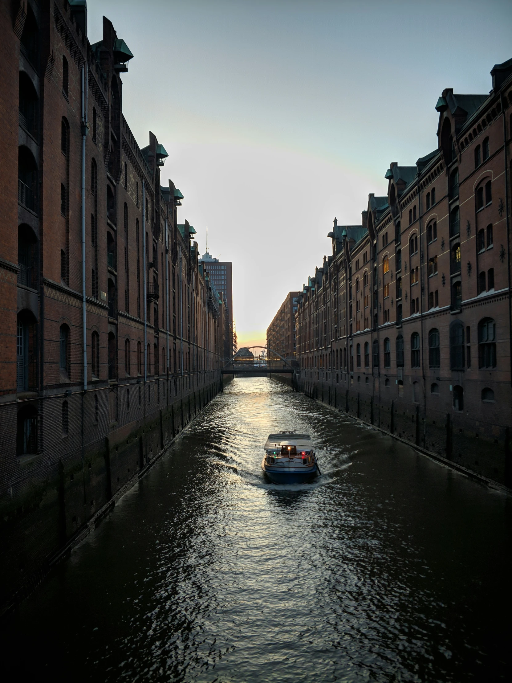 a long canal with a small boat moving in it