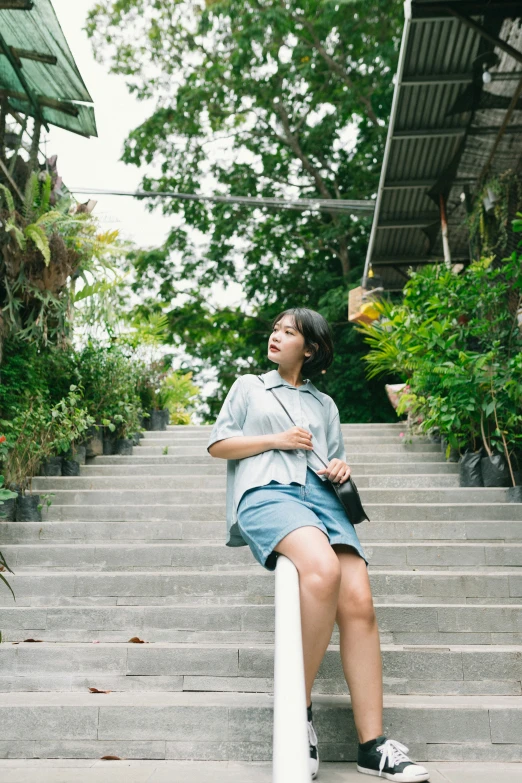 there is a young woman sitting on steps looking up