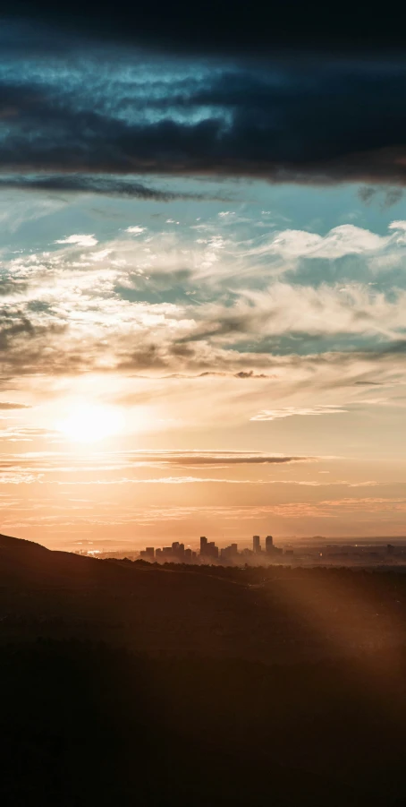 a man riding a skateboard down a hill with the sun behind him