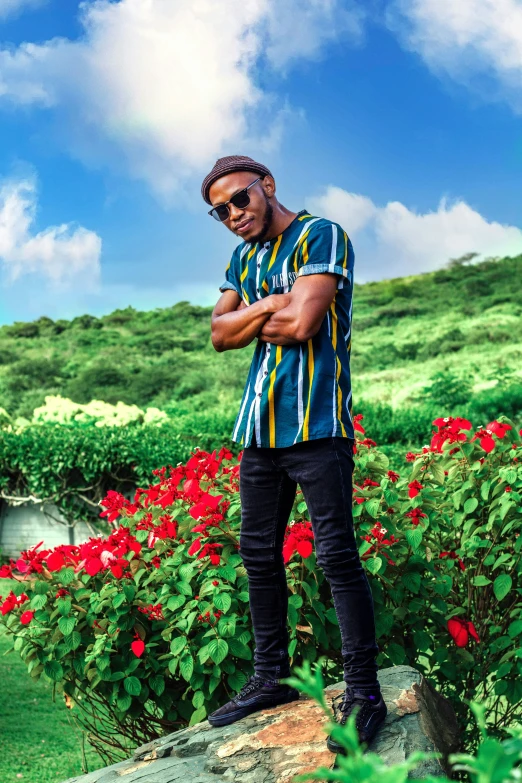 a man is standing on a rock among flowers