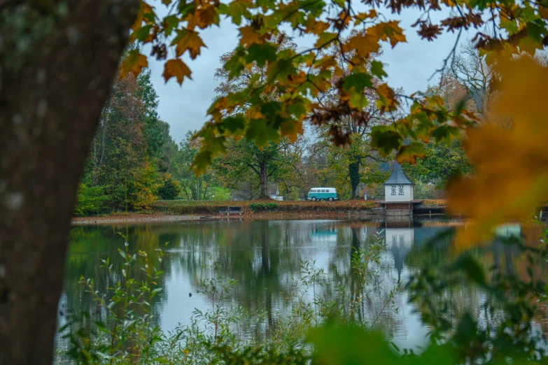 a small church and water mill sit at the edge of a pond