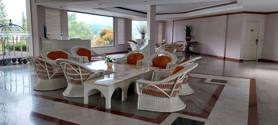 a dining room table with rattan chairs around it