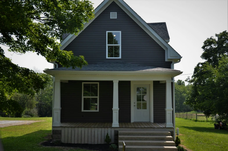 the house is grey with two white pillars